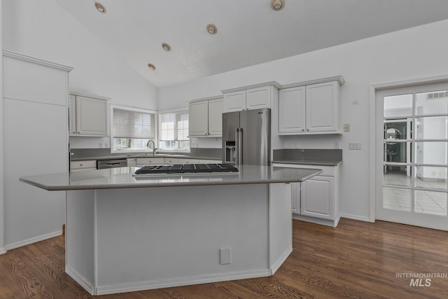 kitchen with high vaulted ceiling, dark wood-style flooring, baseboards, appliances with stainless steel finishes, and a kitchen island