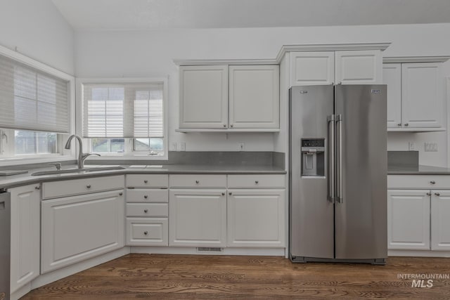 kitchen with visible vents, a sink, white cabinetry, dark countertops, and appliances with stainless steel finishes