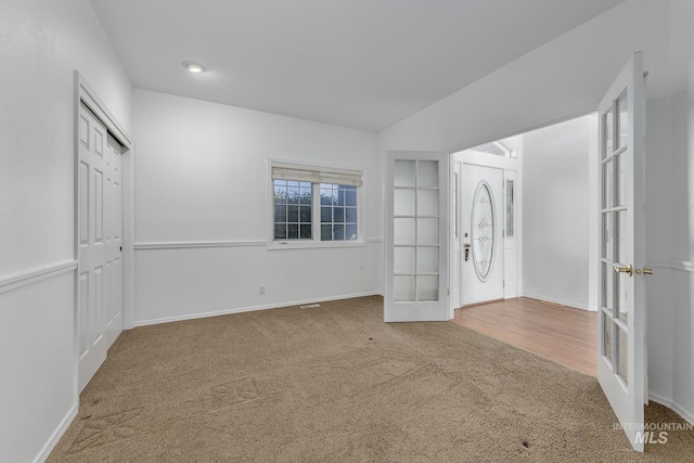 foyer featuring carpet flooring, french doors, and baseboards