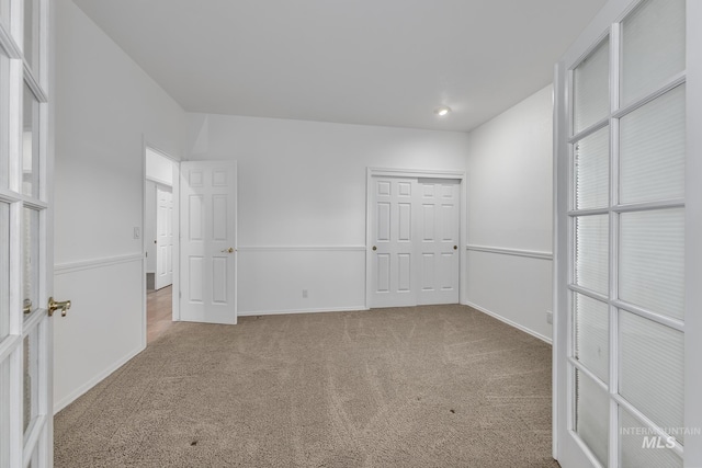 unfurnished bedroom featuring baseboards, carpet flooring, and a closet