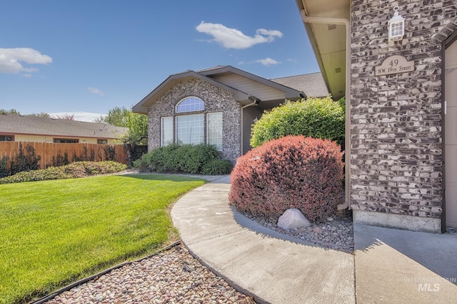 exterior space featuring a lawn and fence