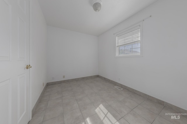 unfurnished room with baseboards and visible vents