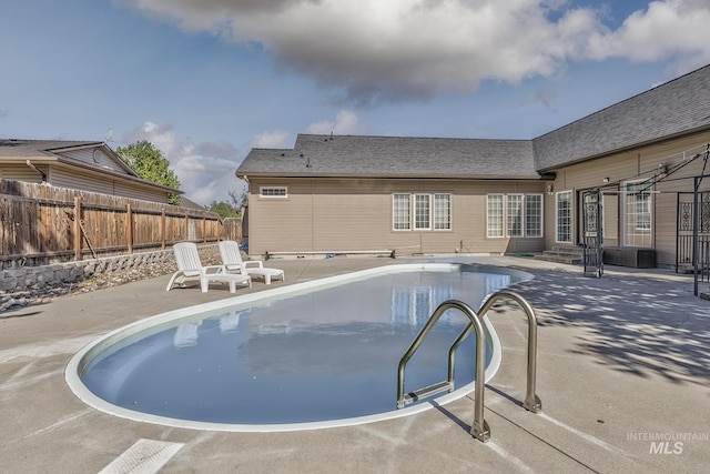 view of swimming pool featuring a patio area, entry steps, a fenced in pool, and fence