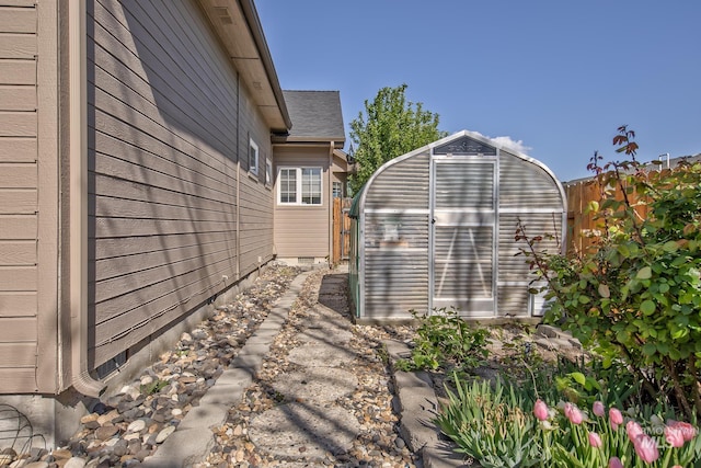 view of home's exterior featuring fence, an outbuilding, and an exterior structure