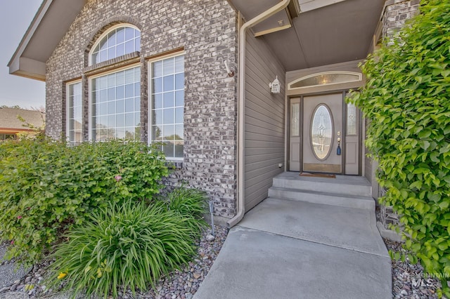 view of exterior entry with brick siding