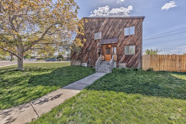 view of front of house featuring fence and a front yard