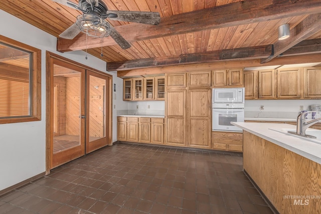 kitchen with light countertops, beam ceiling, white appliances, and wooden ceiling