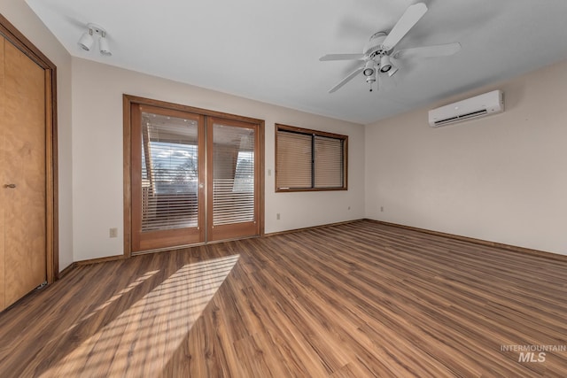unfurnished room with an AC wall unit, baseboards, ceiling fan, and wood finished floors