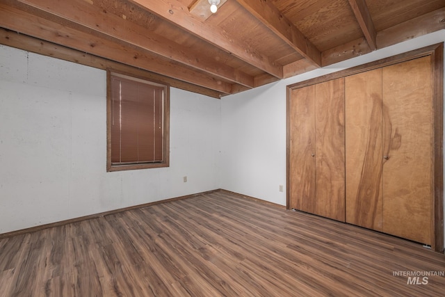 interior space with beamed ceiling, baseboards, and wood finished floors