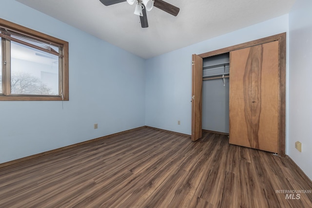 unfurnished bedroom featuring ceiling fan, a closet, and dark wood finished floors
