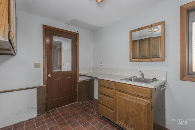 bar with dark tile patterned floors and a sink