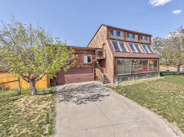 view of front facade featuring a garage, fence, driveway, and a front lawn