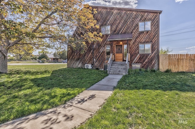 view of front of property featuring fence and a front lawn