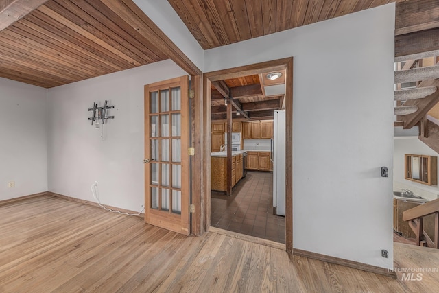spare room featuring baseboards, stairs, wood ceiling, and wood finished floors