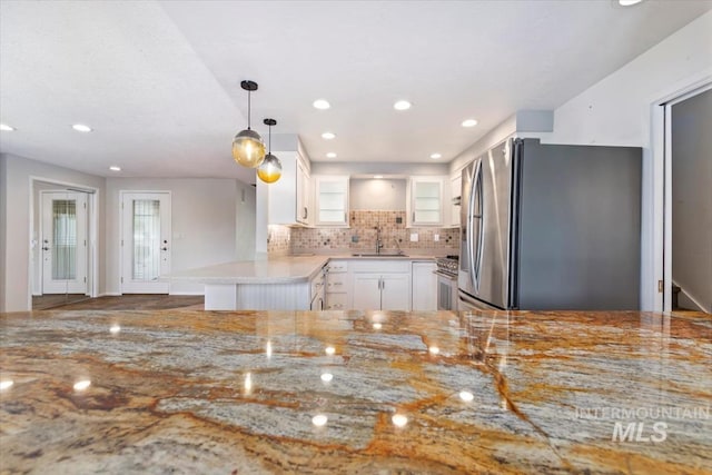 7301 W Diamond St, Boise, ID 83709 - kitchen with stainless steel appliances, a sink, white cabinetry, light stone countertops, and glass insert cabinets