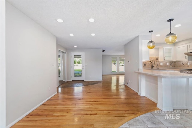 7301 W Diamond St, Boise, ID 83709 - kitchen featuring a sink, light wood-style floors, light countertops, white cabinetry, and recessed lighting