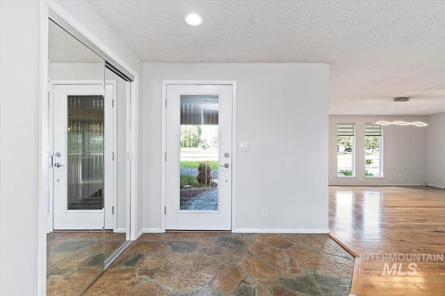 7301 W Diamond St, Boise, ID 83709 - entryway with a textured ceiling, baseboards, and stone finish floors