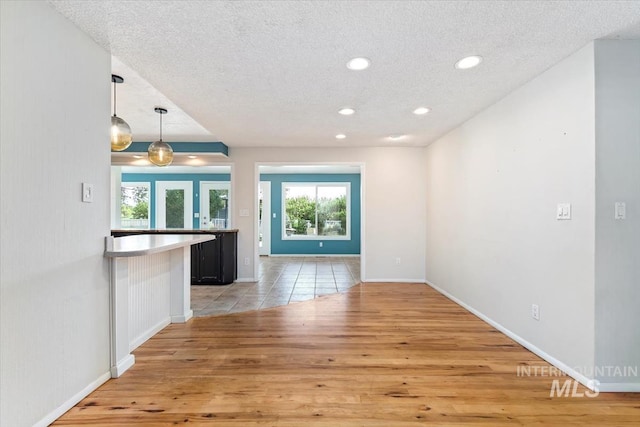 7301 W Diamond St, Boise, ID 83709 - unfurnished living room with light wood-style floors, a textured ceiling, recessed lighting, and baseboards