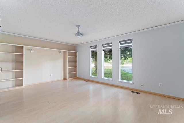 7301 W Diamond St, Boise, ID 83709 - spare room featuring wood finished floors, a textured ceiling, baseboards, built in features, and ornamental molding