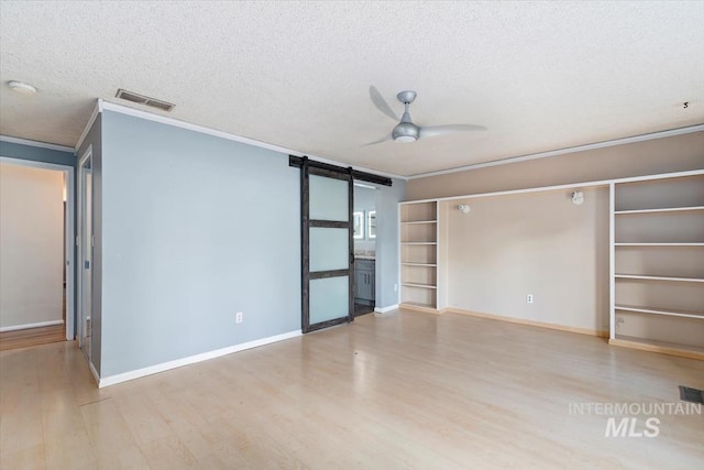 7301 W Diamond St, Boise, ID 83709 - unfurnished room featuring a barn door, crown molding, a ceiling fan, wood finished floors, and a textured ceiling