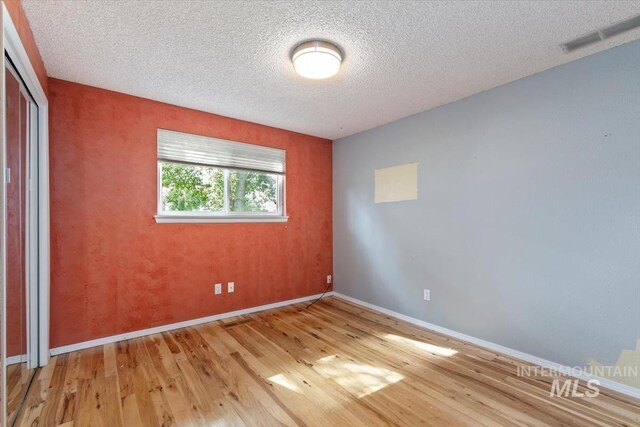 7301 W Diamond St, Boise, ID 83709 - unfurnished bedroom with light wood-type flooring, a closet, baseboards, and a textured ceiling