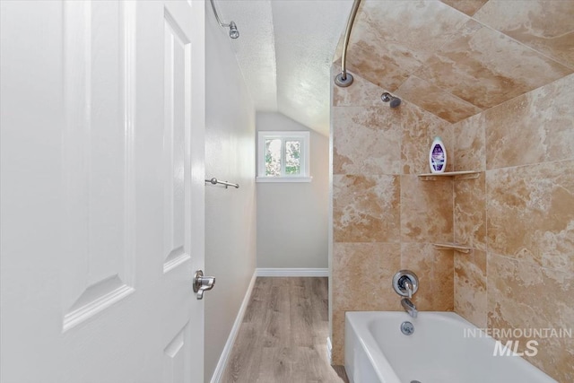 7301 W Diamond St, Boise, ID 83709 - full bath with vaulted ceiling, wood finished floors, baseboards, shower / washtub combination, and a textured ceiling