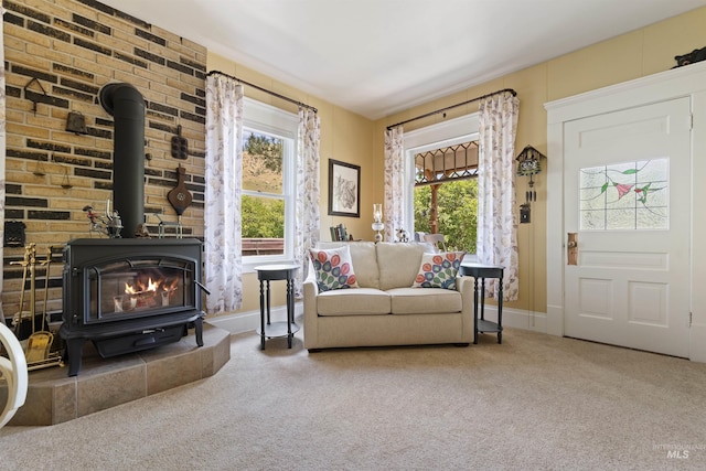 living room with a healthy amount of sunlight, carpet, and a wood stove