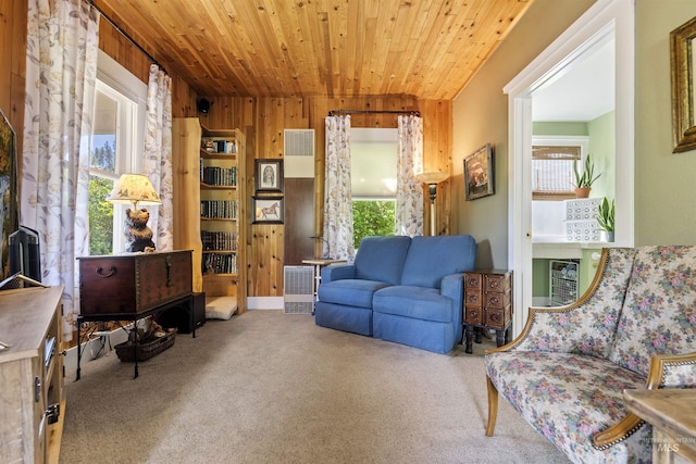 sitting room featuring wood ceiling, wood walls, carpet flooring, and a wealth of natural light