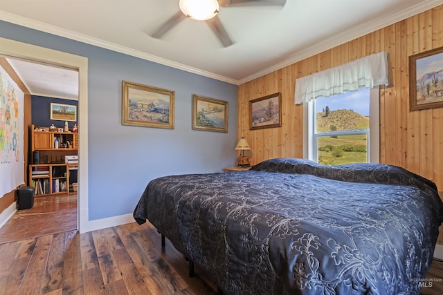 bedroom featuring crown molding, ceiling fan, dark hardwood / wood-style floors, and wood walls