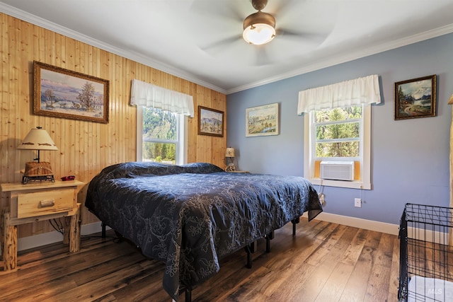 bedroom featuring ceiling fan, cooling unit, dark hardwood / wood-style floors, ornamental molding, and wood walls