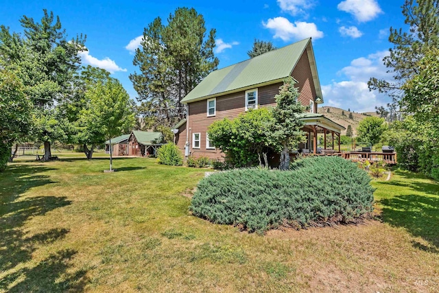 view of property exterior with a yard and a deck