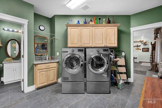 laundry room featuring cabinets, sink, and washing machine and clothes dryer