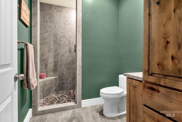 bathroom featuring toilet and tiled shower