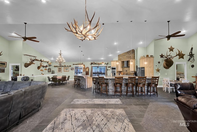 living room featuring ceiling fan with notable chandelier and high vaulted ceiling