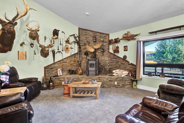 living room with a wood stove, carpet floors, and vaulted ceiling