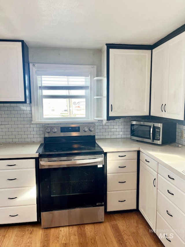 kitchen with backsplash, appliances with stainless steel finishes, and light countertops