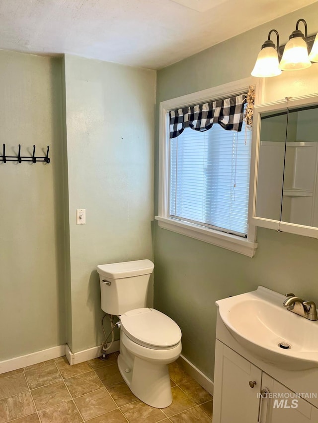 bathroom with vanity, toilet, and baseboards
