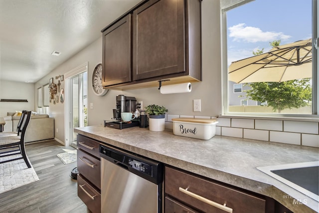 kitchen featuring stainless steel dishwasher, dark brown cabinets, and light hardwood / wood-style flooring