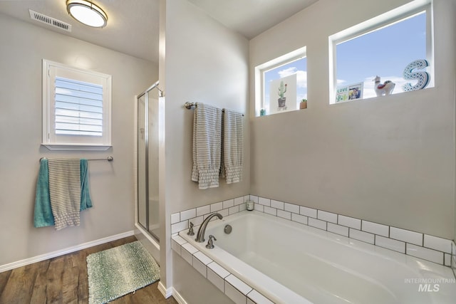 bathroom featuring wood-type flooring, shower with separate bathtub, and a wealth of natural light