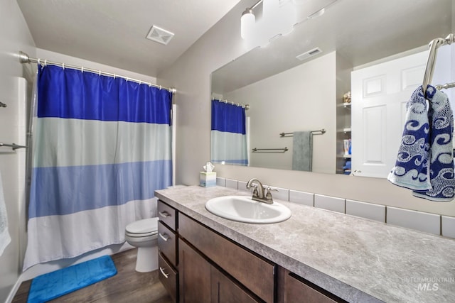 full bathroom featuring hardwood / wood-style floors, vanity, shower / bath combination with curtain, and toilet