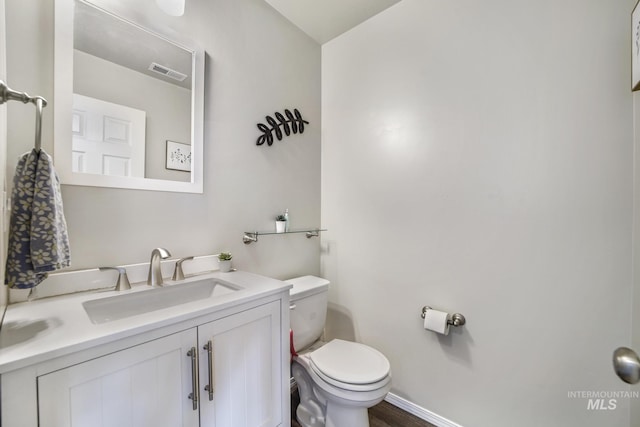 bathroom featuring vanity, hardwood / wood-style flooring, and toilet