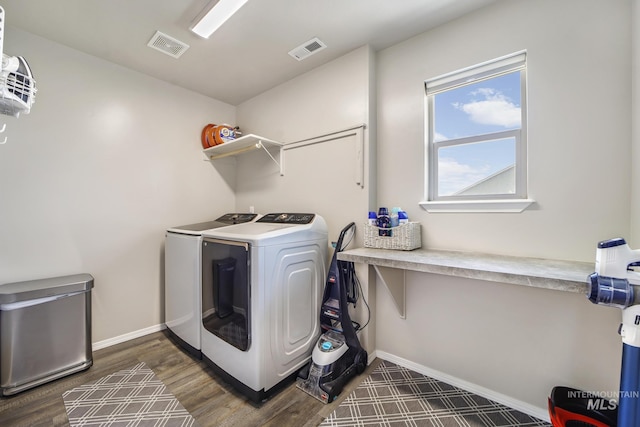 clothes washing area featuring dark hardwood / wood-style flooring and washer and clothes dryer