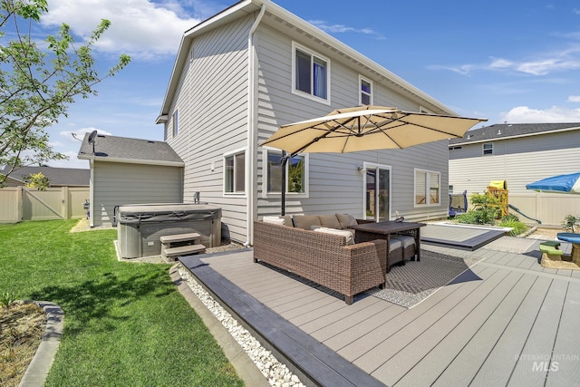 back of property with a lawn, outdoor lounge area, a hot tub, and a deck