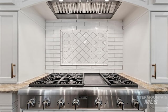 1552 W Windbreaker Ln, Eagle, ID 83616 - kitchen with arched walkways, custom exhaust hood, white cabinets, light stone counters, and range