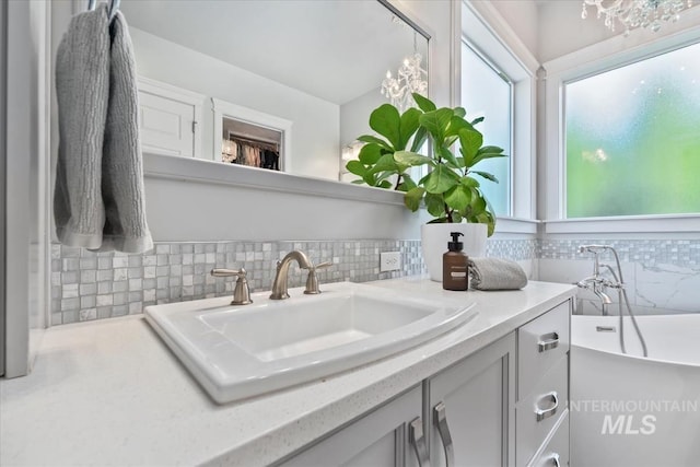 1552 W Windbreaker Ln, Eagle, ID 83616 - bathroom with decorative backsplash, vanity, healthy amount of natural light, and a freestanding bath