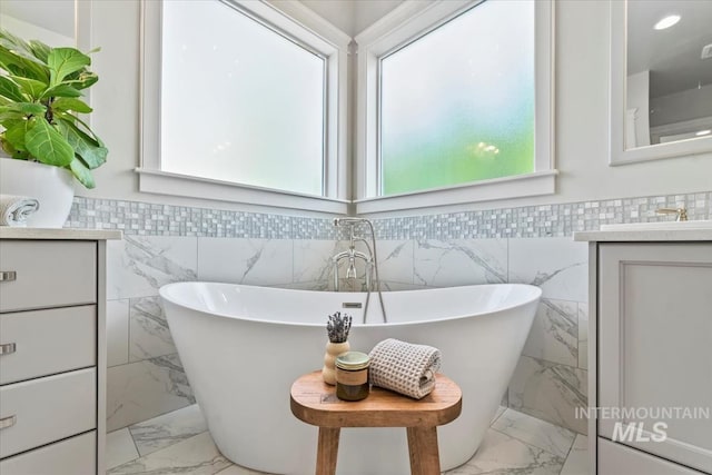 1552 W Windbreaker Ln, Eagle, ID 83616 - full bathroom with vanity, marble finish flooring, a freestanding tub, and tile walls