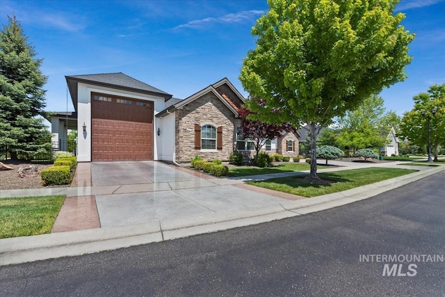 1552 W Windbreaker Ln, Eagle, ID 83616 - view of front of property with concrete driveway, stone siding, a garage, and a front yard