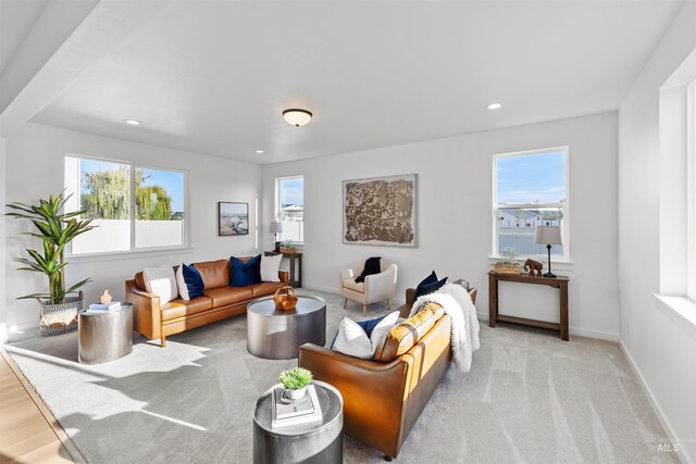 carpeted living area featuring plenty of natural light, recessed lighting, and baseboards