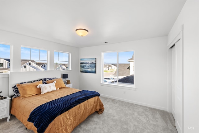 bedroom featuring carpet floors, baseboards, and a closet