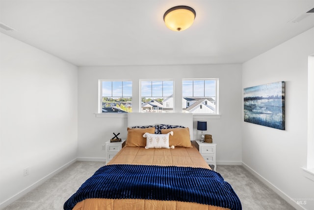 bedroom with light colored carpet and baseboards